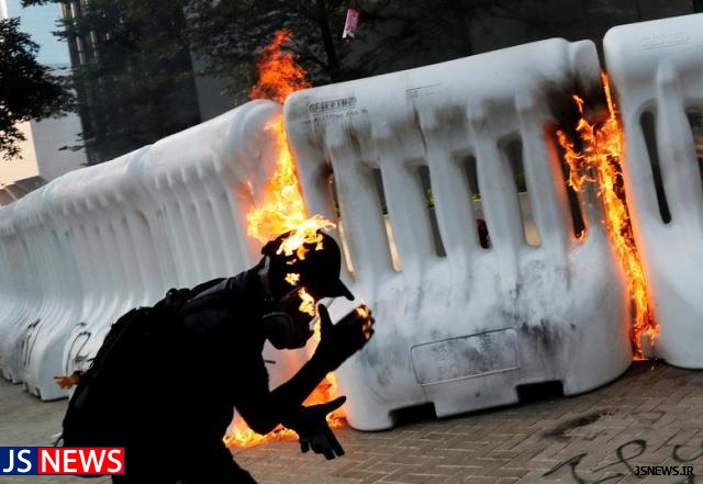 عکس روز : یک معترض هنگ کنگی در حال پرتاب مواد آتش زا